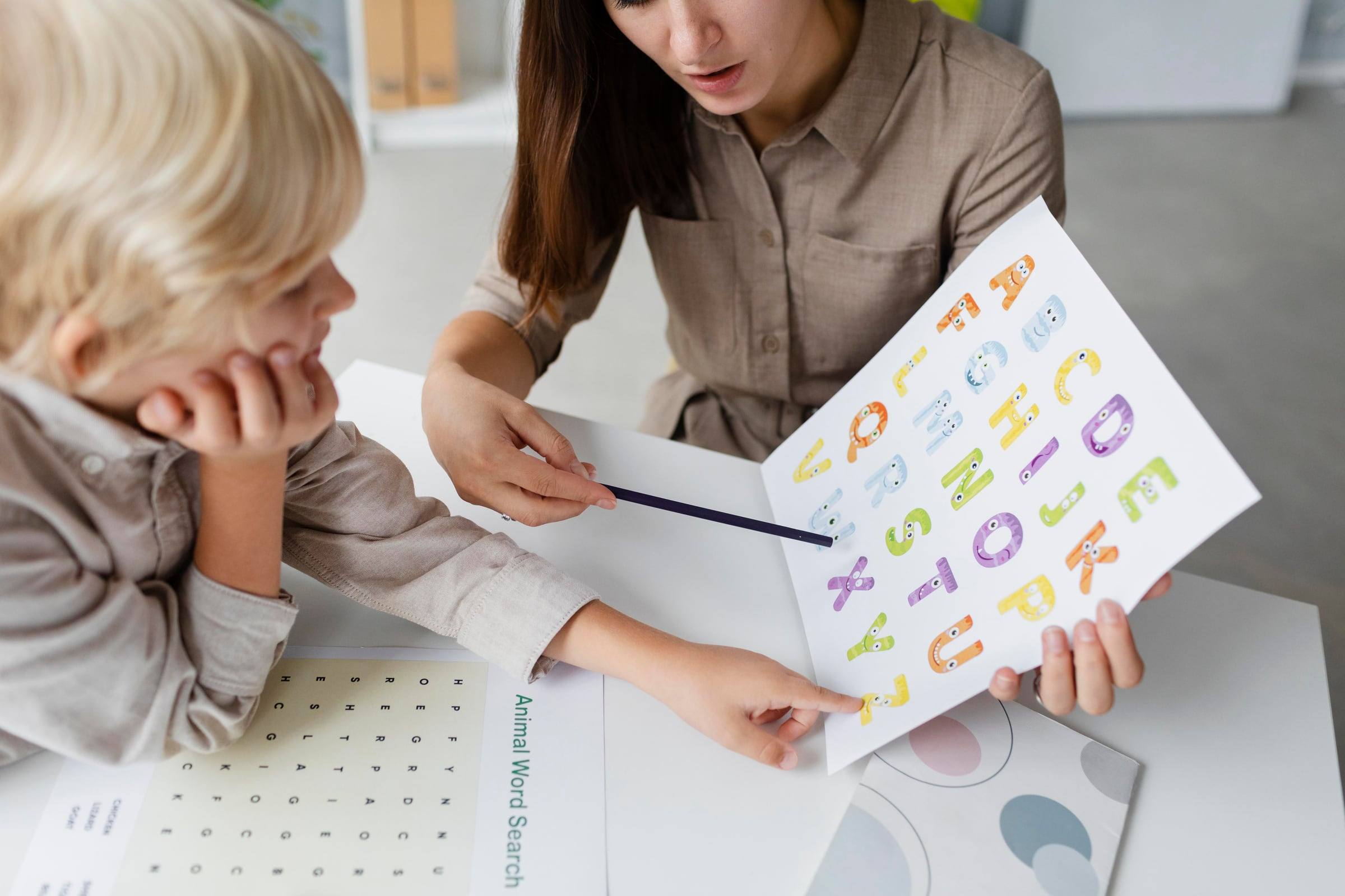 Especialista mostrando un abecedario ilustrado a un niño
